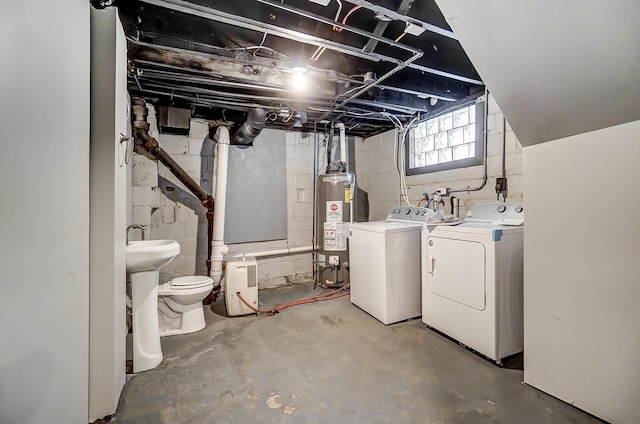 basement with washing machine and dryer, gas water heater, and sink