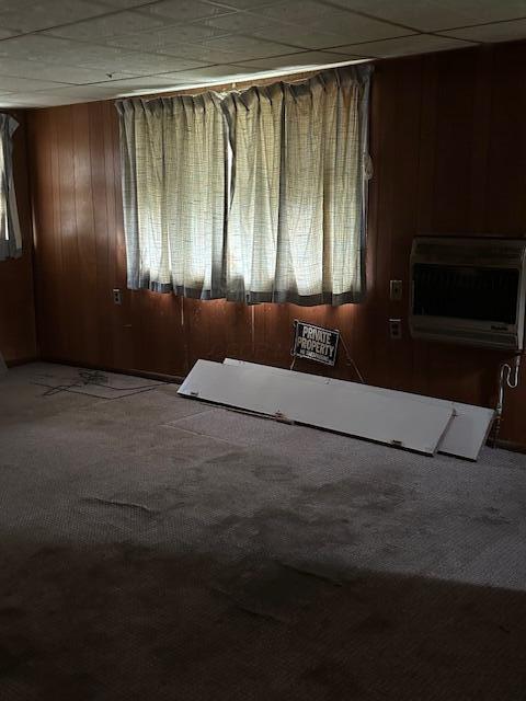 unfurnished room featuring a paneled ceiling, a healthy amount of sunlight, carpet floors, and a wall mounted AC