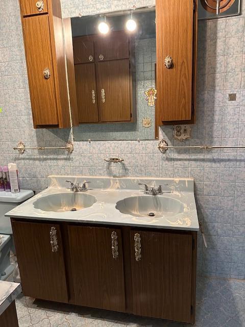 bathroom featuring vanity, tile walls, and toilet