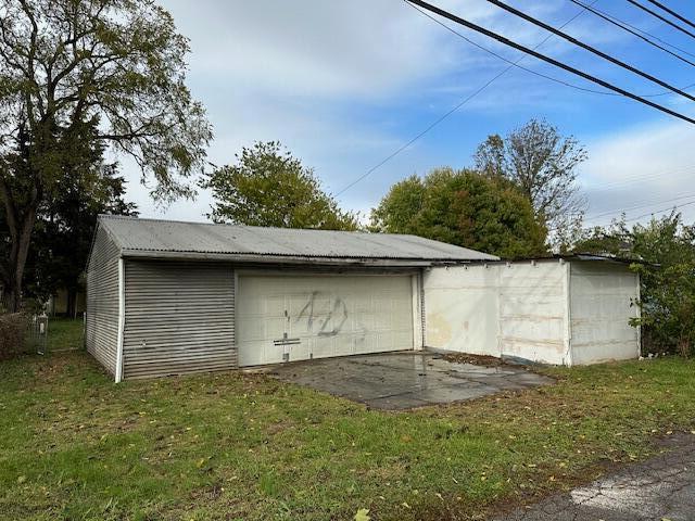 view of outbuilding featuring a lawn and a garage