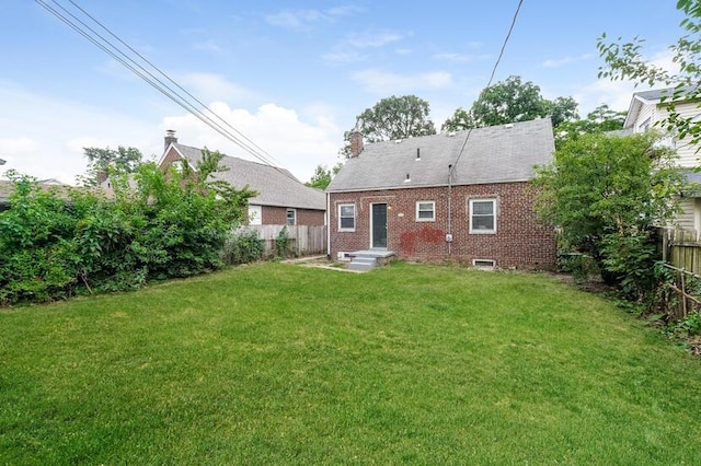 rear view of property with a lawn