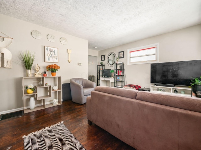 living room featuring dark hardwood / wood-style flooring and a textured ceiling