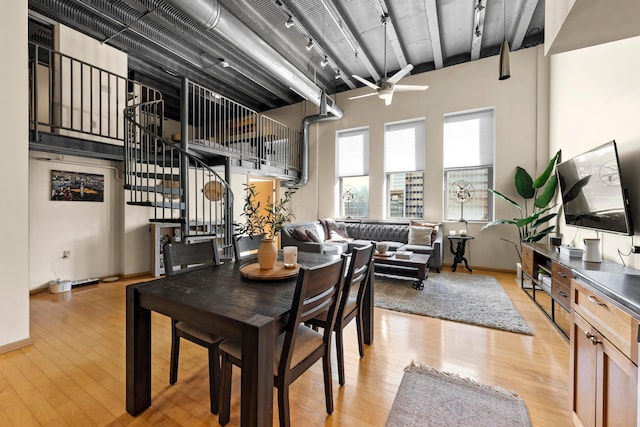 dining space featuring a high ceiling and light wood-type flooring