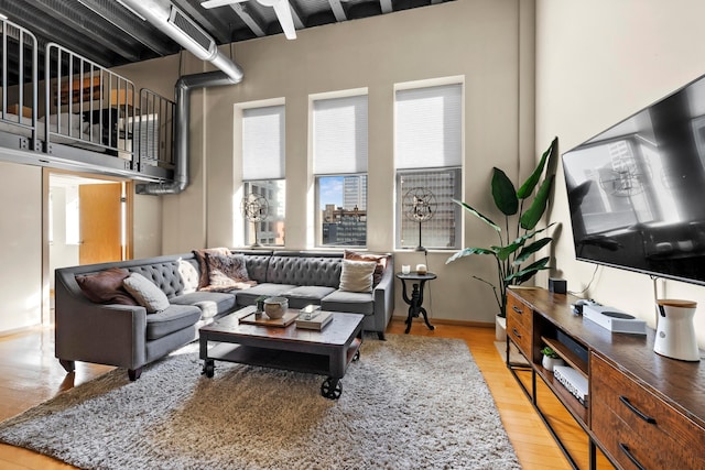 living room featuring light hardwood / wood-style floors and a high ceiling