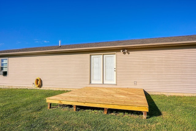 back of property featuring a deck and a lawn