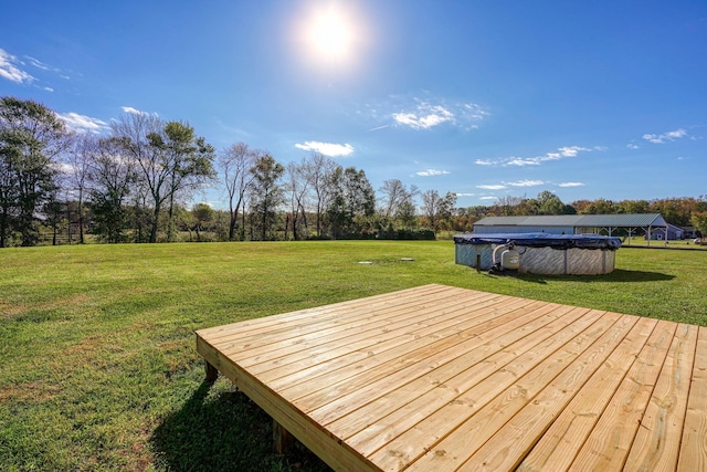 wooden terrace with a yard and a covered pool