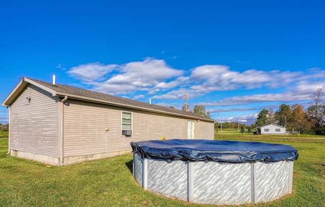 exterior space featuring a covered pool and a lawn