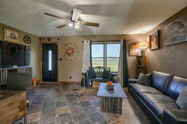 living room featuring ceiling fan and a textured ceiling