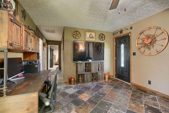 interior space with ceiling fan and a textured ceiling