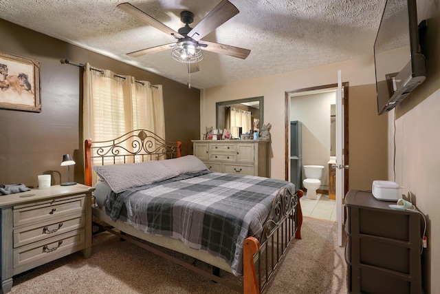 bedroom featuring ensuite bath, ceiling fan, light colored carpet, and a textured ceiling