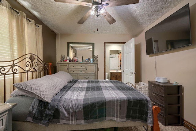 bedroom with ceiling fan, carpet floors, a textured ceiling, and ensuite bath