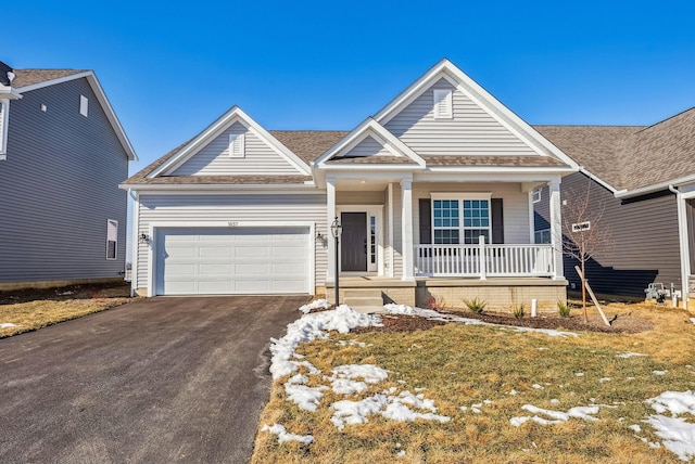 view of front of property with a garage, driveway, a porch, and roof with shingles