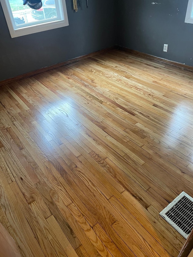 empty room with light hardwood / wood-style flooring