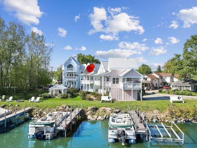 dock area with a yard, a balcony, and a water view