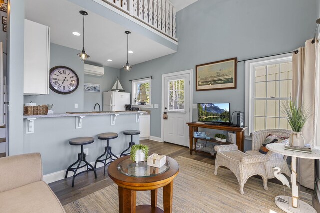 living room featuring a wall mounted air conditioner and dark hardwood / wood-style floors