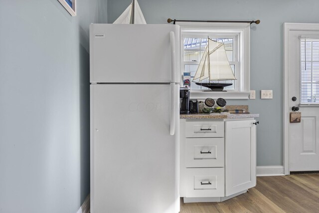 kitchen featuring white fridge, light wood-type flooring, and white cabinetry