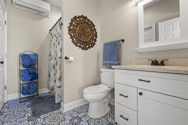 bathroom featuring tile patterned floors, vanity, toilet, and an AC wall unit