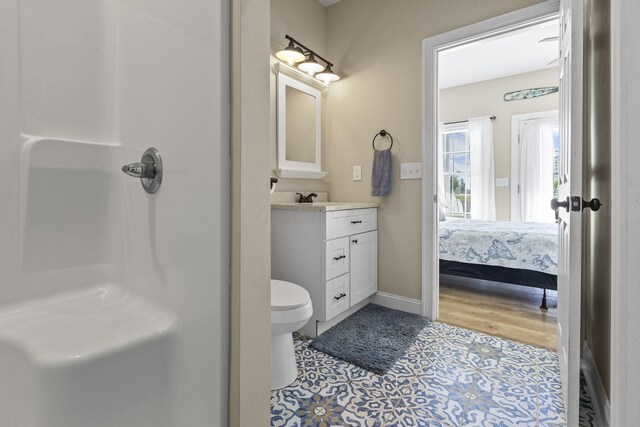 bathroom featuring hardwood / wood-style flooring, vanity, toilet, and a shower