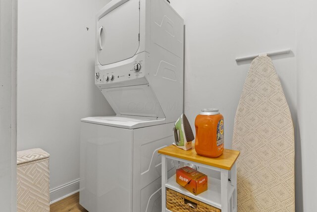 washroom with stacked washer and dryer and wood-type flooring