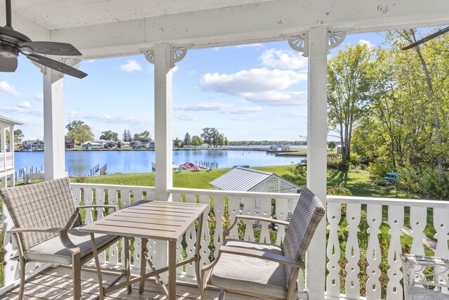 wooden terrace featuring a water view and ceiling fan