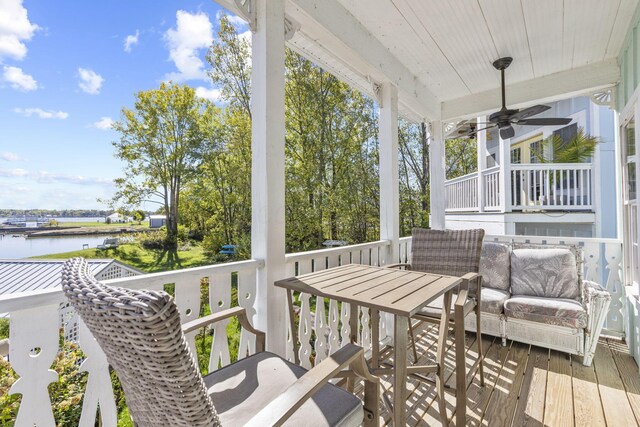 wooden terrace featuring a water view and ceiling fan