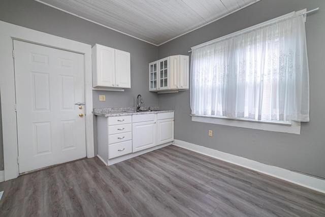 kitchen featuring hardwood / wood-style flooring, white cabinetry, and sink