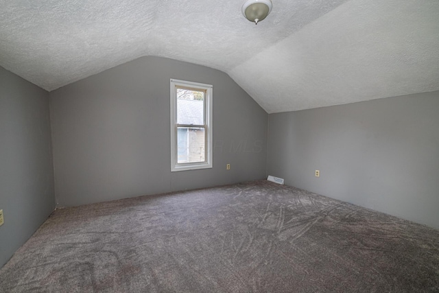 bonus room with carpet flooring, a textured ceiling, and vaulted ceiling