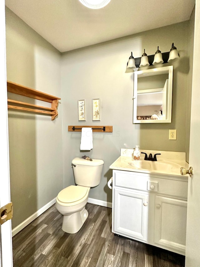 bathroom with vanity, hardwood / wood-style flooring, and toilet