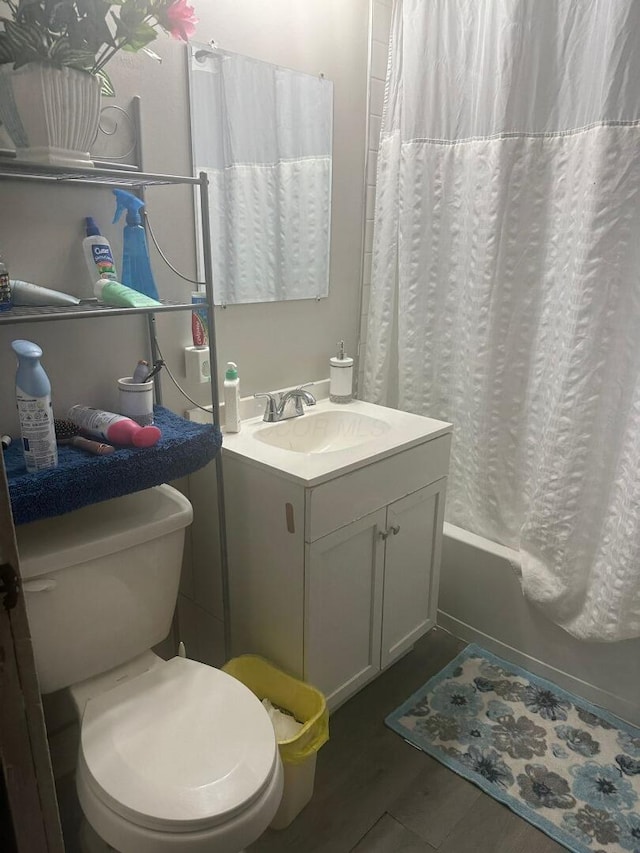 full bathroom featuring vanity, hardwood / wood-style floors, shower / bathtub combination with curtain, and toilet