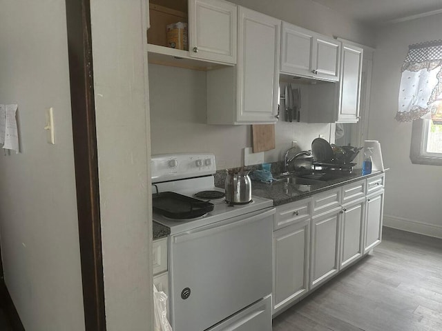 kitchen with white electric range oven, light wood-type flooring, white cabinets, and sink