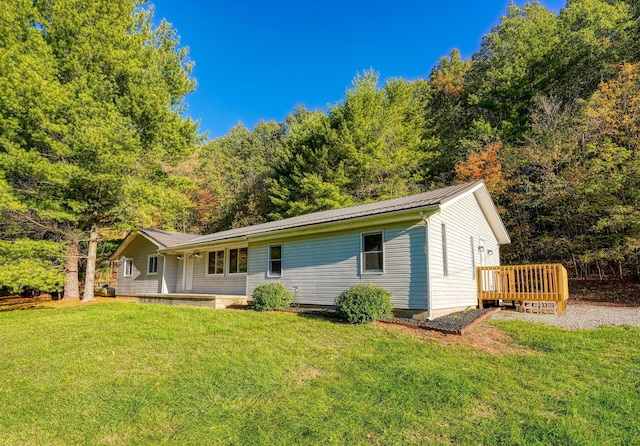 rear view of house with a yard and a wooden deck