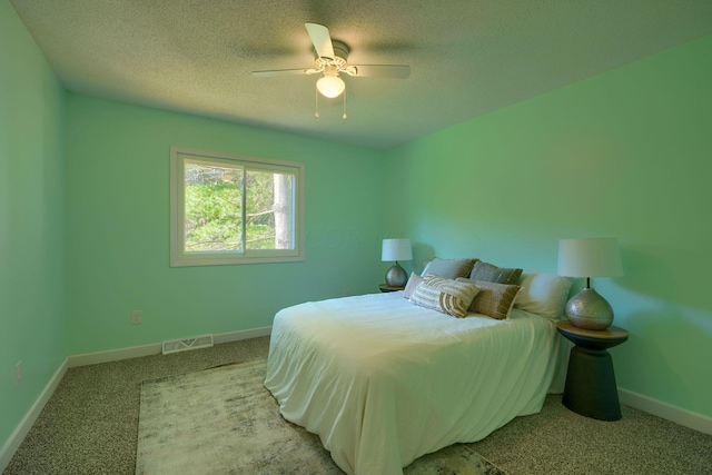 carpeted bedroom featuring a textured ceiling and ceiling fan