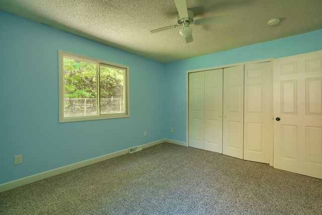 unfurnished bedroom with a closet, carpet floors, ceiling fan, and a textured ceiling