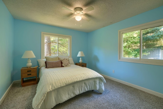 bedroom with a textured ceiling, ceiling fan, and carpet