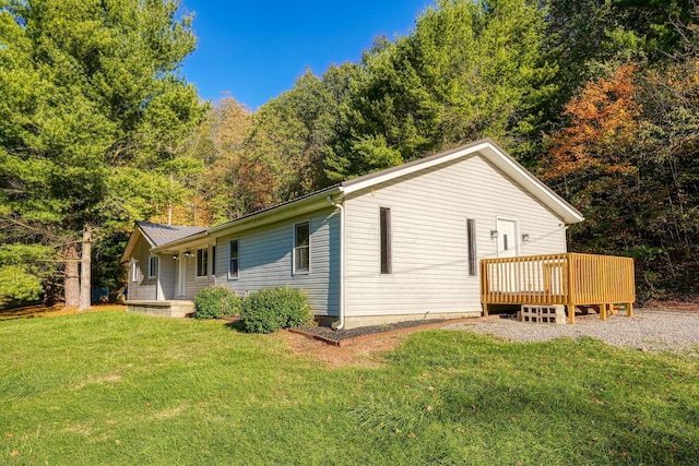 view of side of property featuring a deck and a lawn