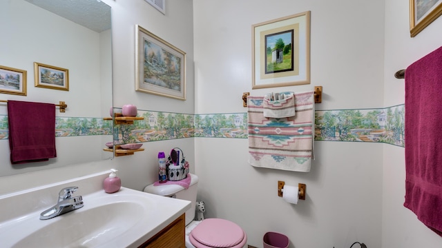 bathroom featuring vanity, toilet, and a textured ceiling