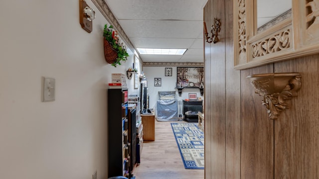 hallway featuring a paneled ceiling and light hardwood / wood-style floors