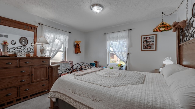 bedroom featuring light colored carpet and a textured ceiling