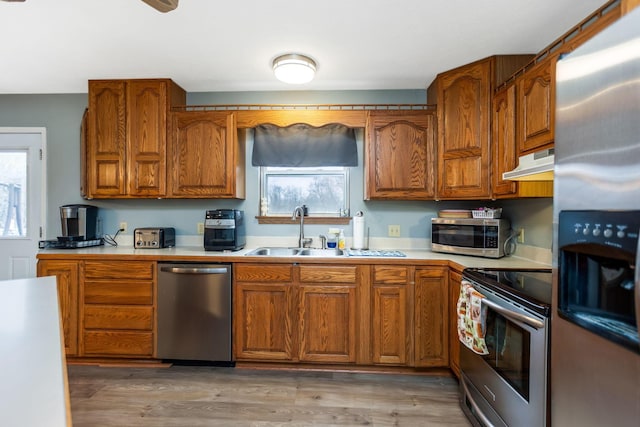 kitchen featuring wood-type flooring, stainless steel appliances, a wealth of natural light, and sink