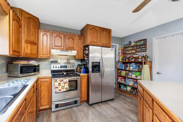 kitchen with ceiling fan, sink, light hardwood / wood-style floors, and appliances with stainless steel finishes