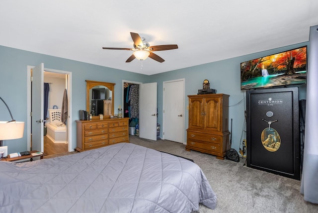 bedroom with ensuite bath, ceiling fan, and light carpet