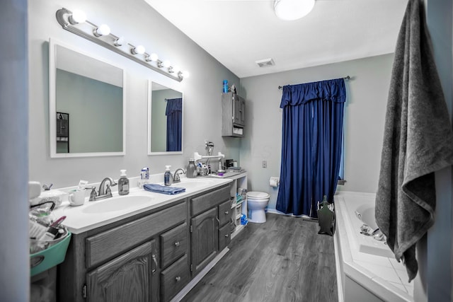 bathroom featuring vanity, hardwood / wood-style flooring, toilet, and a bathing tub