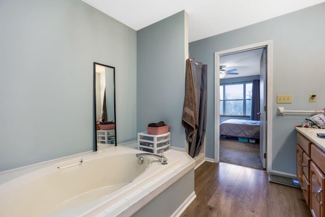 bathroom featuring wood-type flooring, vanity, and a tub