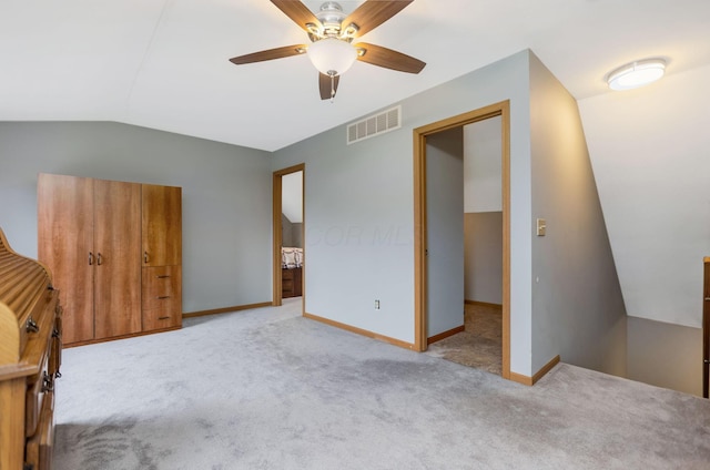 unfurnished bedroom with light carpet, vaulted ceiling, and ceiling fan