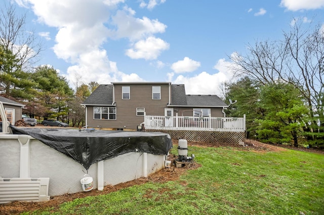 rear view of property with a yard and a pool side deck