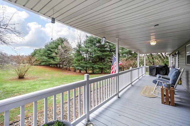 wooden terrace with area for grilling and a yard