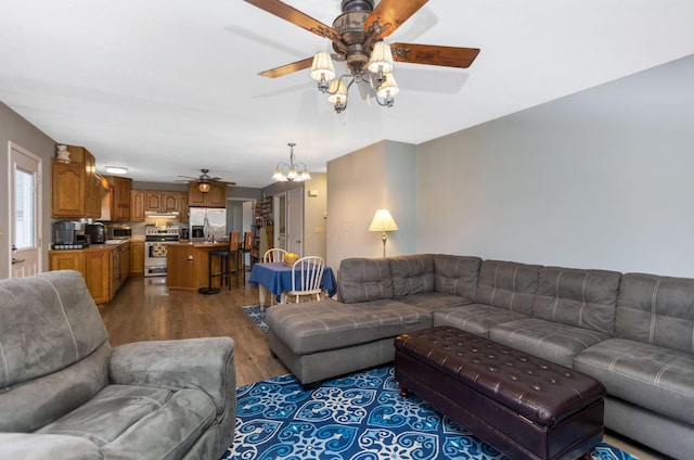 living room with ceiling fan with notable chandelier and wood-type flooring