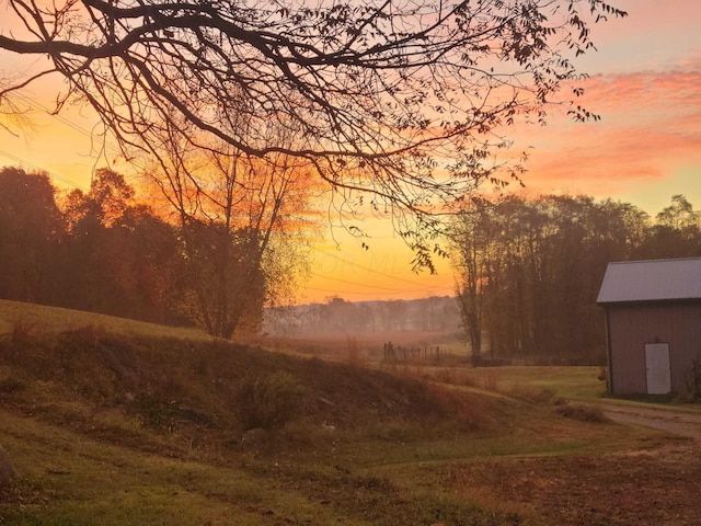 yard at dusk featuring a storage shed