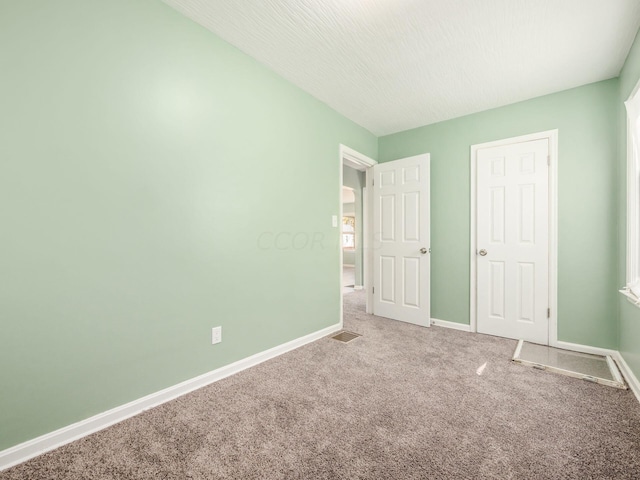 unfurnished bedroom with carpet and a textured ceiling