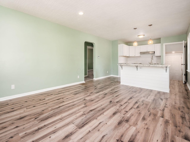 interior space with sink, light wood-type flooring, and a textured ceiling